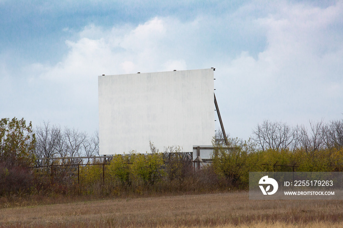 A screen at a drive in theater in a rural area suddenly popular in a covid-19 pandemic