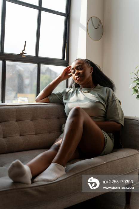 Portrait of young woman resting on sofa at home