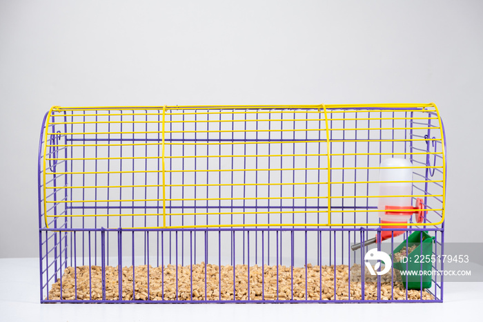 Guinea pig cage with feeder, drinking bottle and wood filler on a white background.