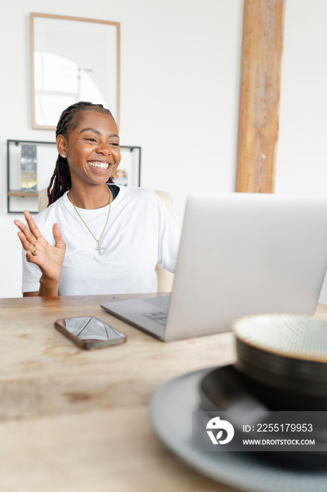 Cheerful woman working on laptop at home