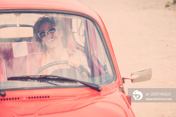 Cheerful happy lady caucasian middle age curly female smile and laugh driving her old retro beautiful car - woman insurance concept for happy people traveling