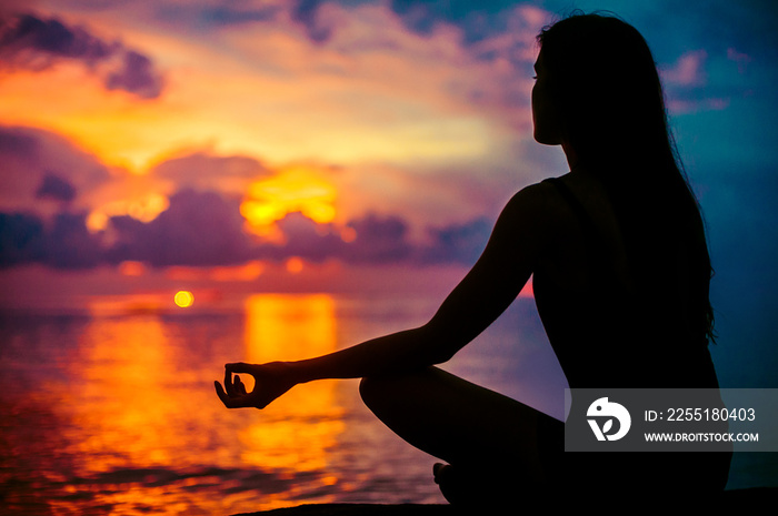 Woman meditating, relaxing in yoga pose at sunset, zen meditation