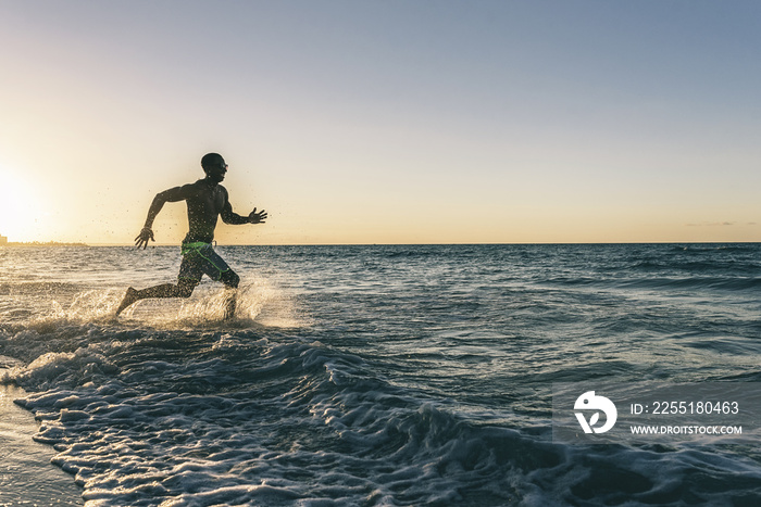 Young man running into the beach. Happy attitude.