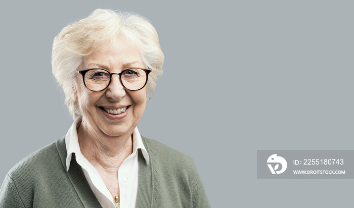 Happy senior woman posing on gray background