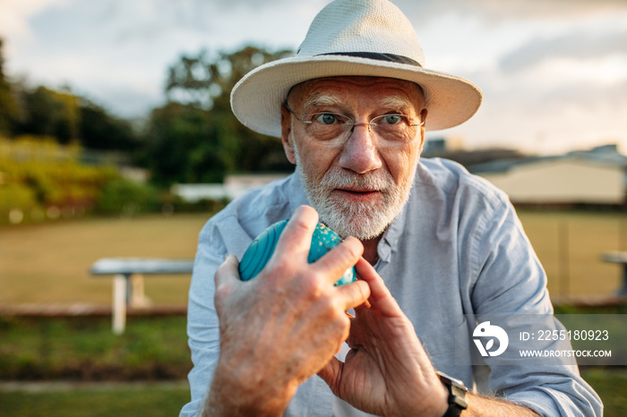 Close up of a man playing boules