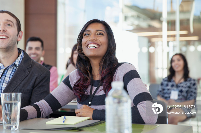 Woman smiling during business seminar.