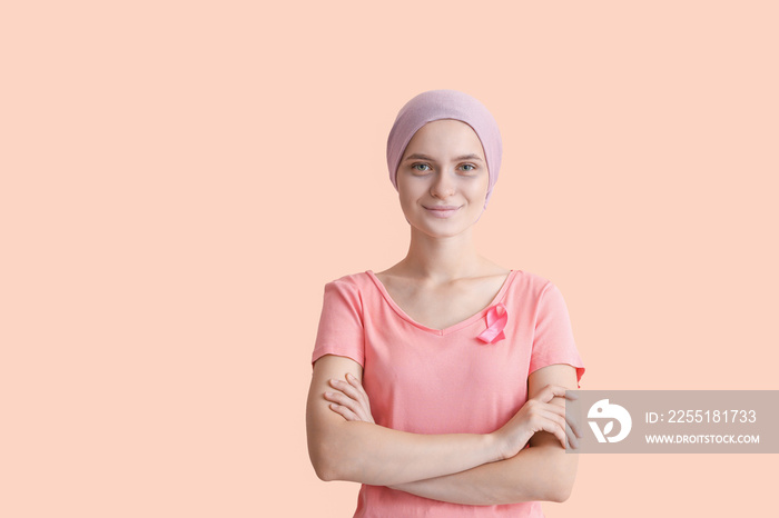Woman after chemotherapy with pink ribbon on color background. Breast cancer awareness