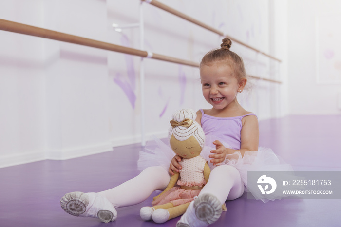 Little beautiful happy girl laughing, having fun at ballet school, copy space. Adorable little ballerina laughing excitedly, resting after ballet lesson