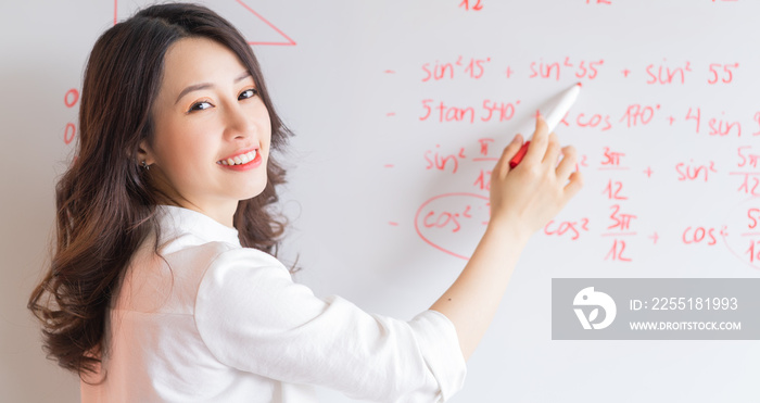 The Asian female teacher is rewriting the lecture on the board