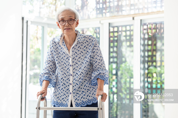 Asian senior woman using walker during rehabilitation, elderly woman with walking and exercising at home