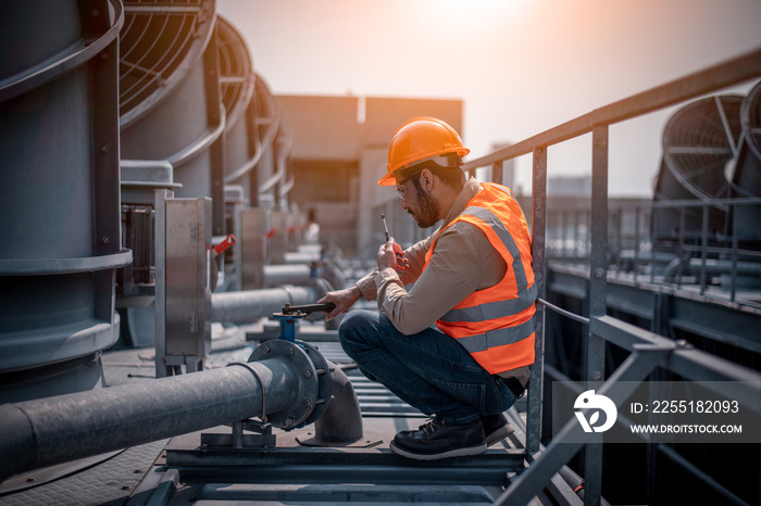 engineer under checking the industry cooling tower air conditioner is water cooling tower air chiller HVAC of large industrial building to control air system.