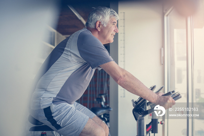 Caucasian man working out on elliptical machine.