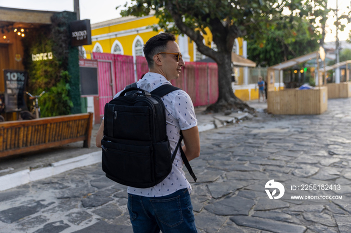 Rear view of man with backpack in old town