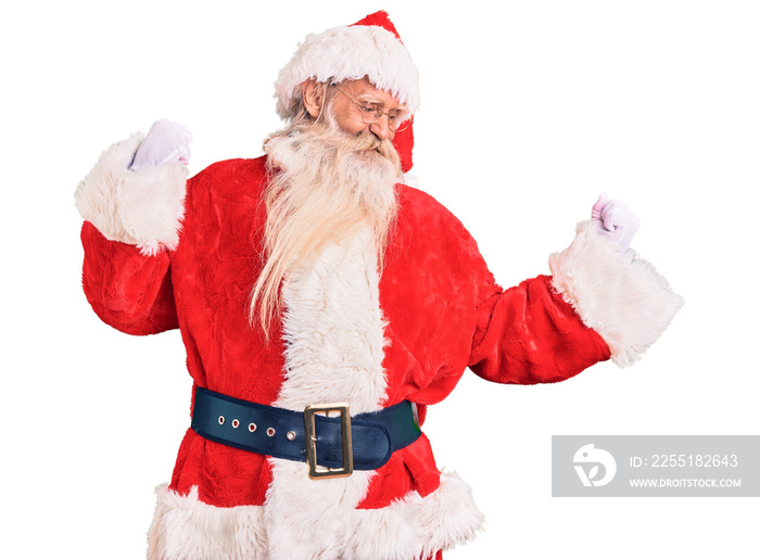 Old senior man with grey hair and long beard wearing traditional santa claus costume dancing happy and cheerful, smiling moving casual and confident listening to music