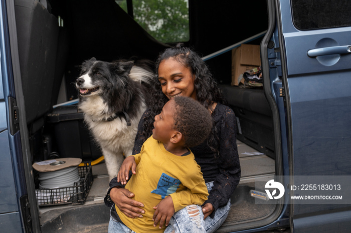 Mother with son and dog in van preparing for trip