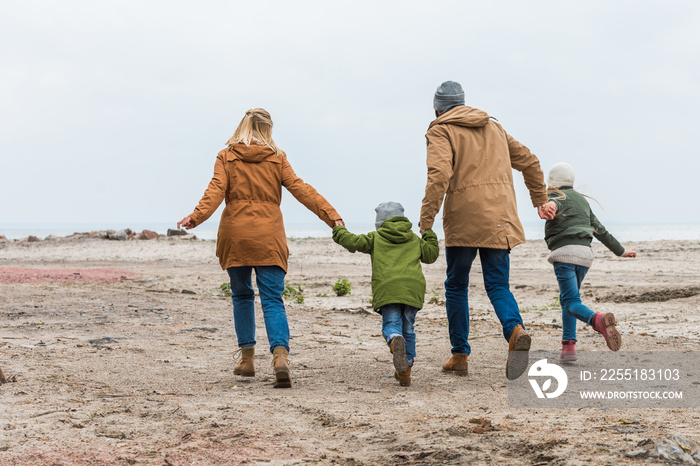 family holding hands and walking by seashore