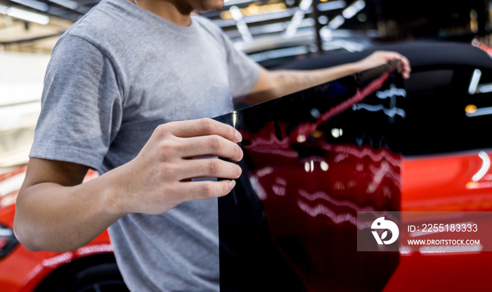 Applying tinting foil on a car window in a auto service