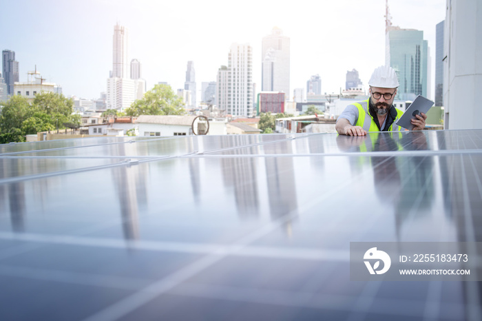 Rooftop solar power plant engineers sitting and examining photovoltaic panels. Concept of alternative energy and its service. Electrical and instrument technician use laptop to maintenance electric sy