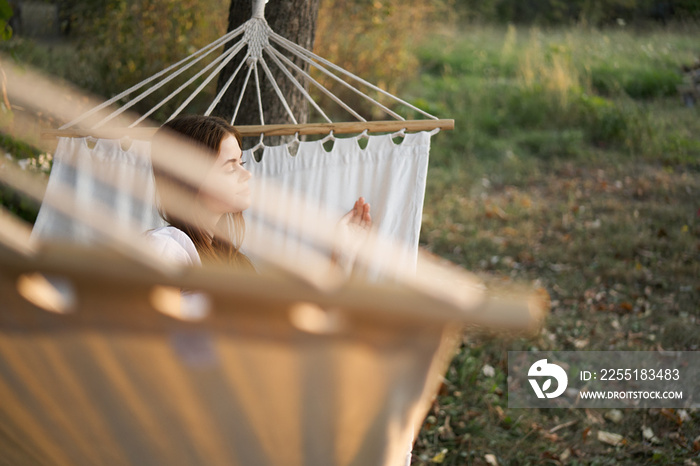 woman relaxing in nature in a hammock garden fresh air