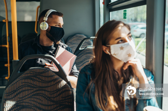 Young handsome man wearing protective mask while riding a bus