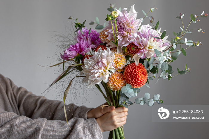 Close-up of a bright festive bouquet with chrysanthemums in female hands.