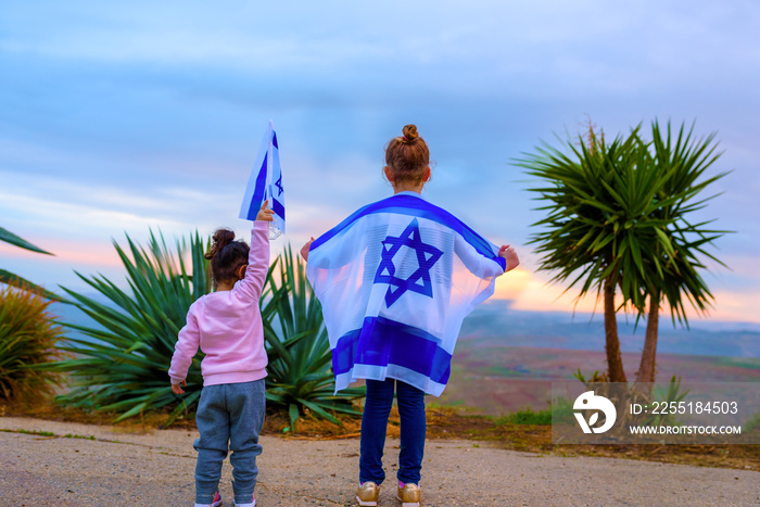 Happy girl sister friends with the flag of Israel at sunset outdoors.