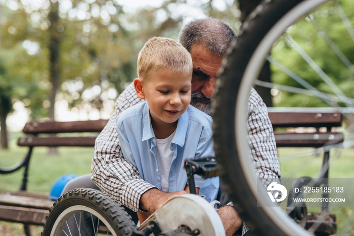 grandfather and grandson fixing bike