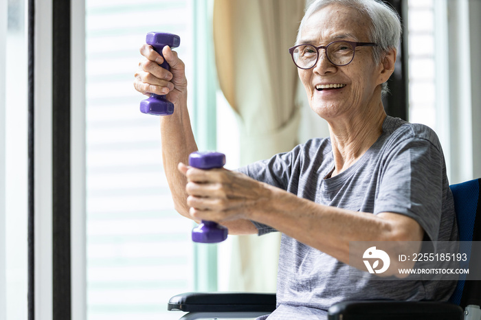 Strong asian senior woman working out with heavy dumbbells,lifting dumbbell weights for strength training,fitness elderly people doing exercise while sit in wheelchair,health care,healthy lifestyle.