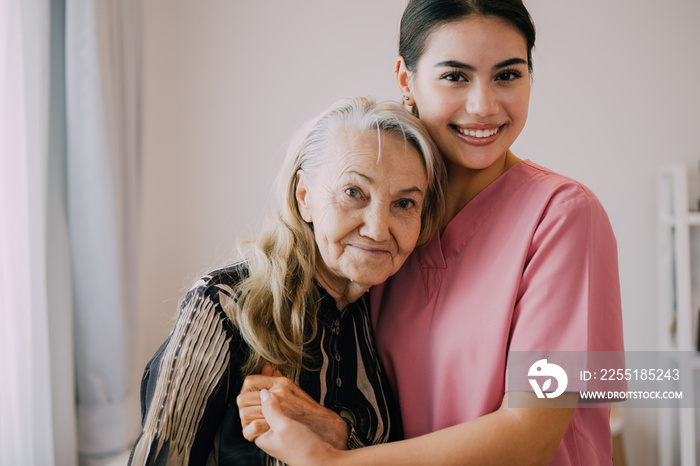 Happy caregiver and senior patient smiling and looking at camera, Senior woman and doctor at home health care visit, Home care and nursing concept