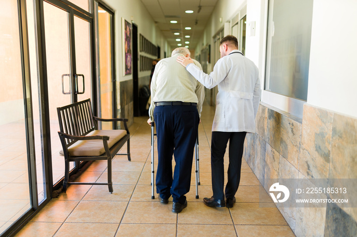 Doctor and retired mature man taking a walk at the retirement home