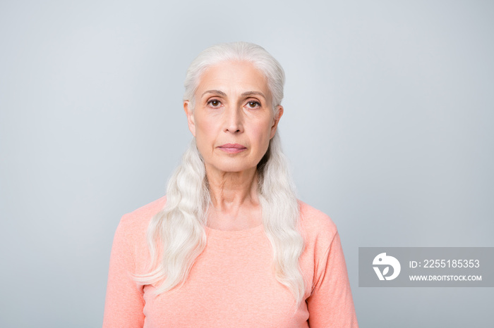 Close-up photo of serious focused attractive old lady wearing simple peach colored pullover isolated grey background