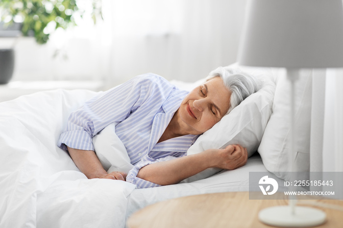 old age and people concept - senior woman sleeping in bed at home bedroom