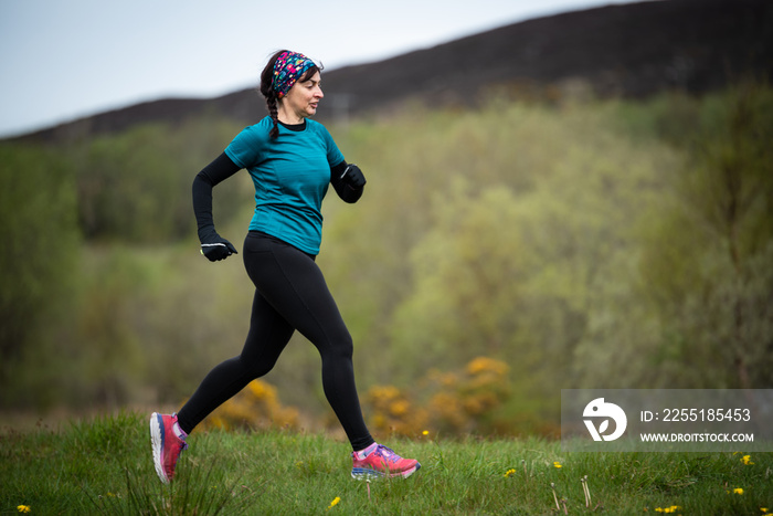 Senior woman in 50s exercising and keeping fit by running in a park