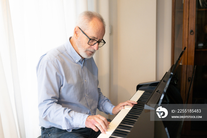 Old man play on piano at home