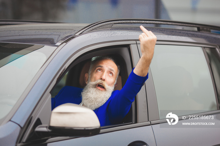 Old brutal man in the car. Angry driver