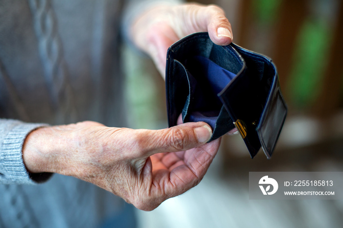 older womans hand holding an empty wallet