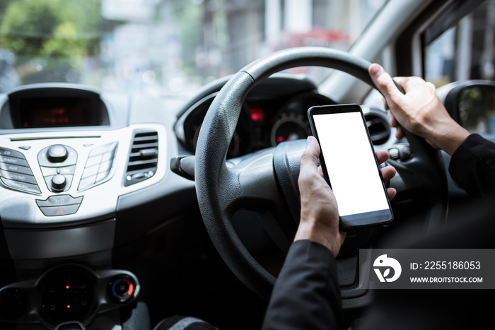 Asian men holding a mobile phone while driving a car.