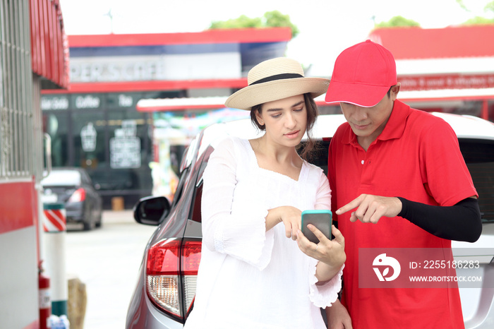 Beautiful woman traveler riding using mobile phone navigation while asking gas station attendant staff for finding right direction, cute female tourist getting lost and confusing in the city, asking f