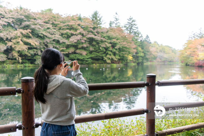 雲場池の紅葉を撮影する日本人の女の子