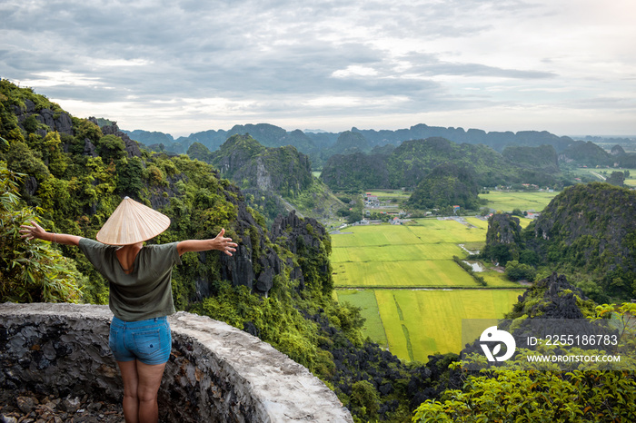 Mujer viajera disfrutando vistas panorámicas de Ninh Binh desde famoso mirador hang mua