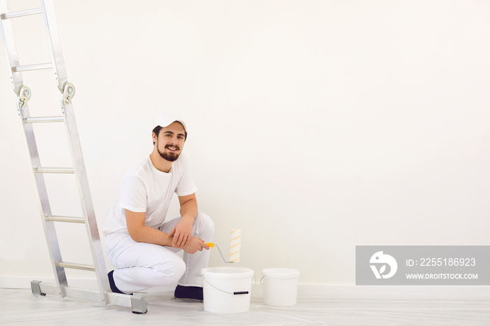 House painter in white uniform on a white background for painting in the room.