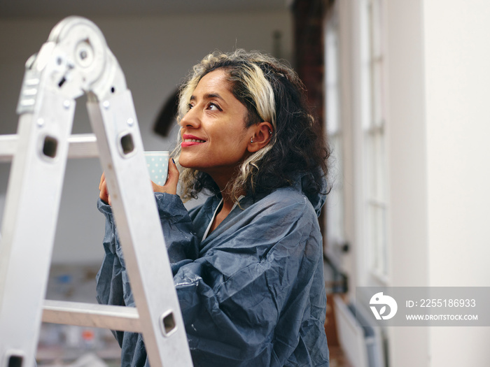 Smiling woman having coffee break during renovation