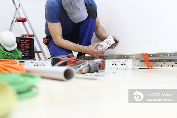 electrician at work with socket in hand, install electric circuits, electrical wiring