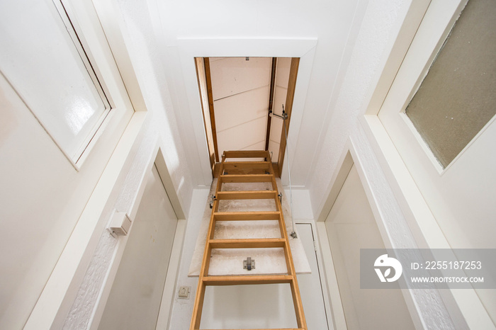 Wooden staircase to the attic in a modern house