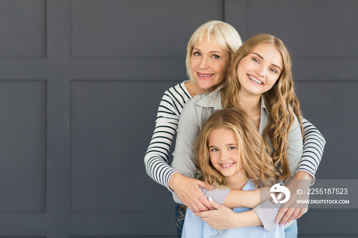 Women hugging, looking at camera and smiling