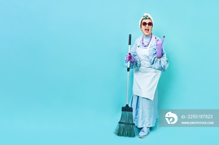 Cleaning Lady Fun. Elderly funky housewife fooling around with a broom. Full body isolated.