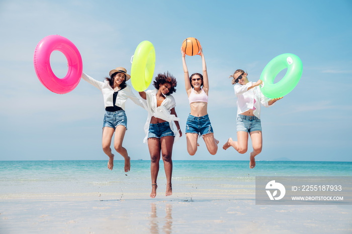 Group of teenage with floaty on the beach having fun in a sunny day,  Summer group of friends at beach.