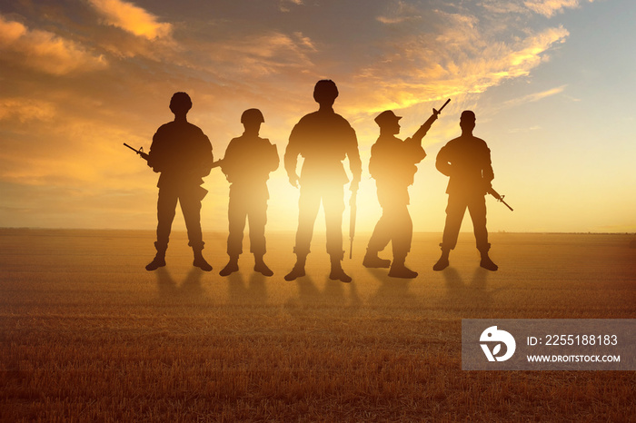 Silhouettes of soldiers in field. War in Ukraine