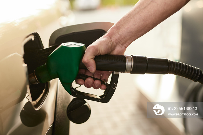 Crop man refueling car at station