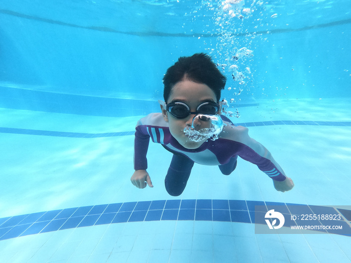 Little boys swimming and diving at the pool under water shot